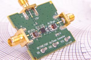 Radio frequency mixer printed circuit board PCB in front of Smith chart for microwave and RF calculations