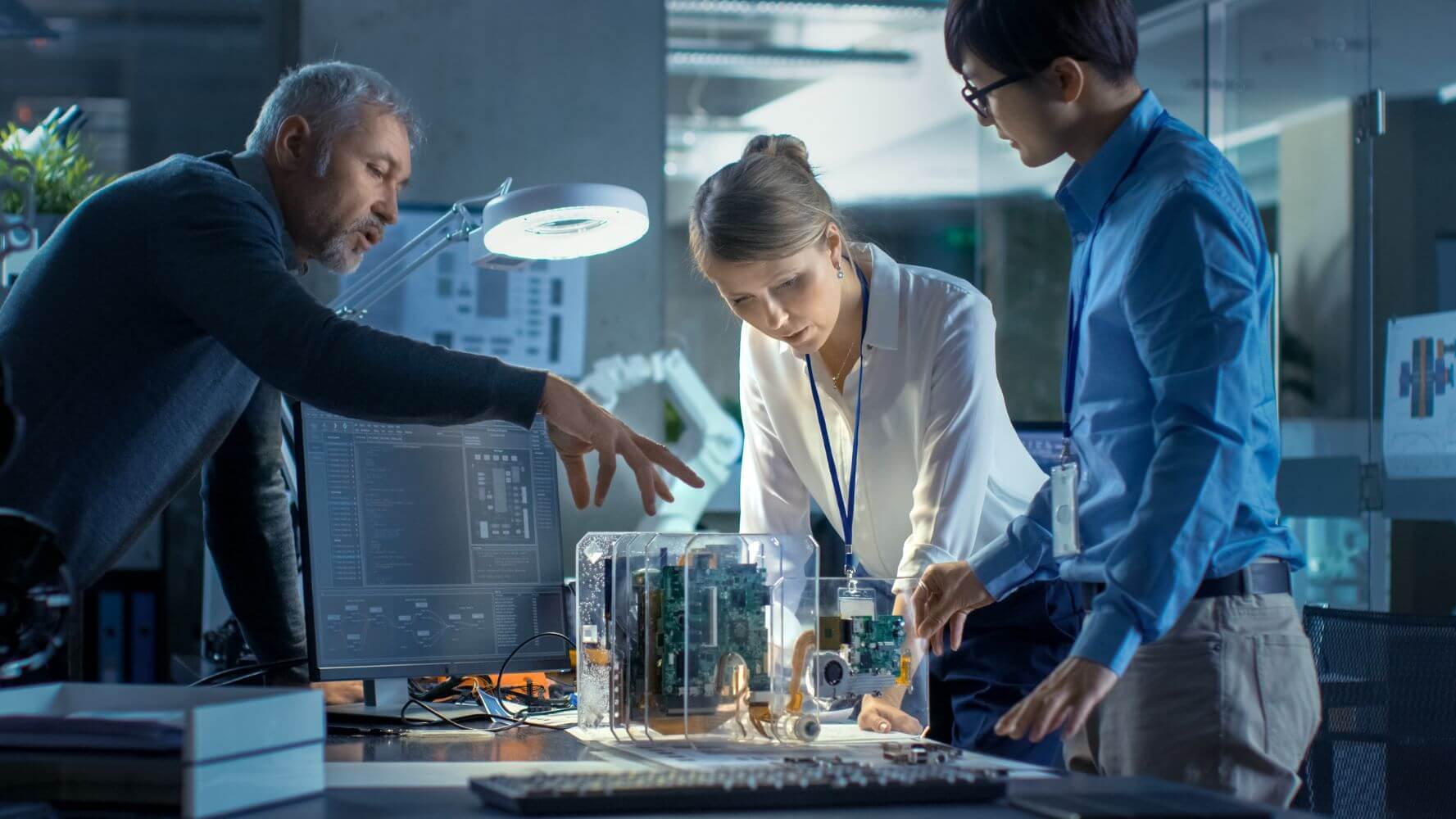 Computer Engineers Lean on the Desk and Choose Printed Circuit Boards to Work with