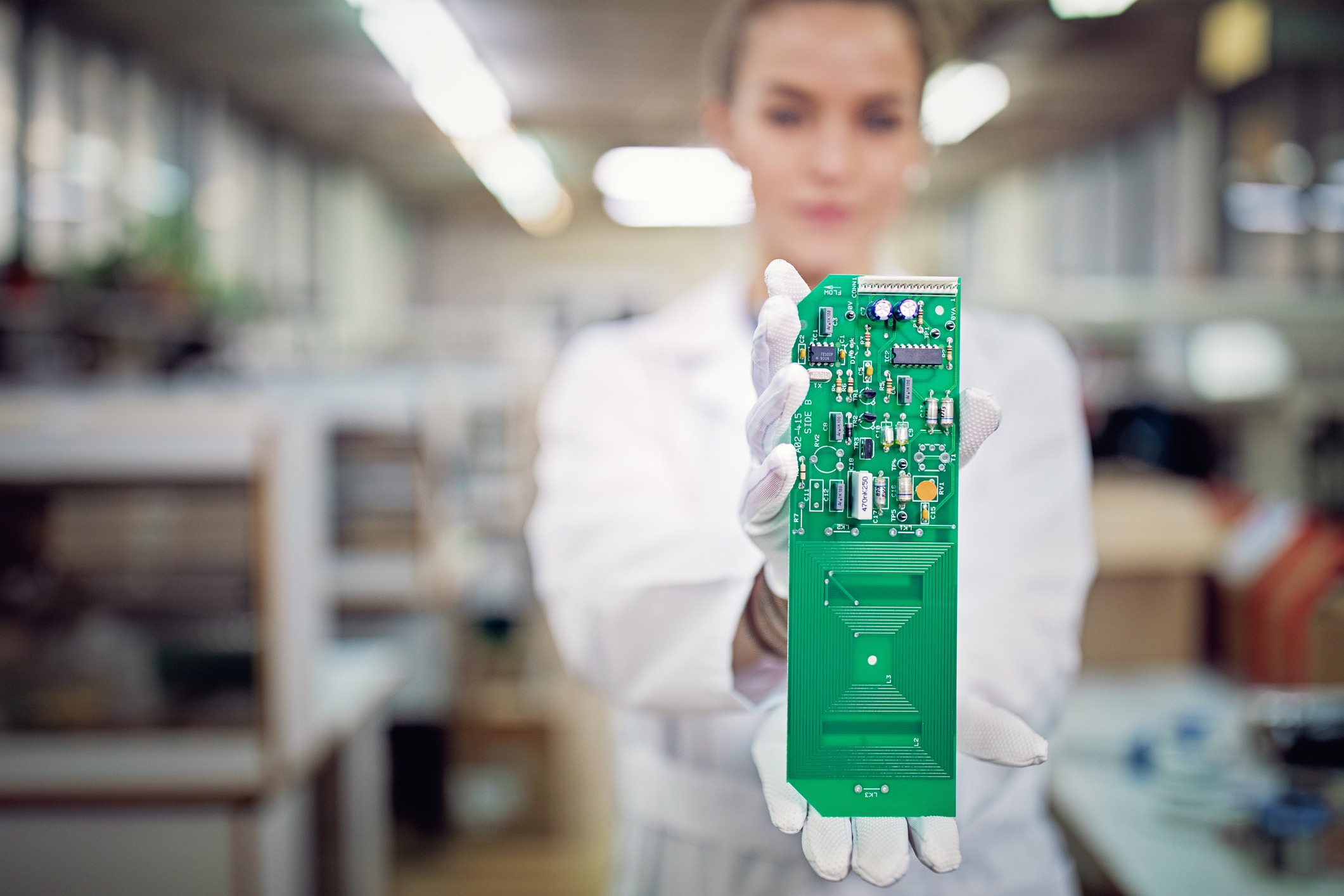 Portrait of woman holding circuit board in a factory